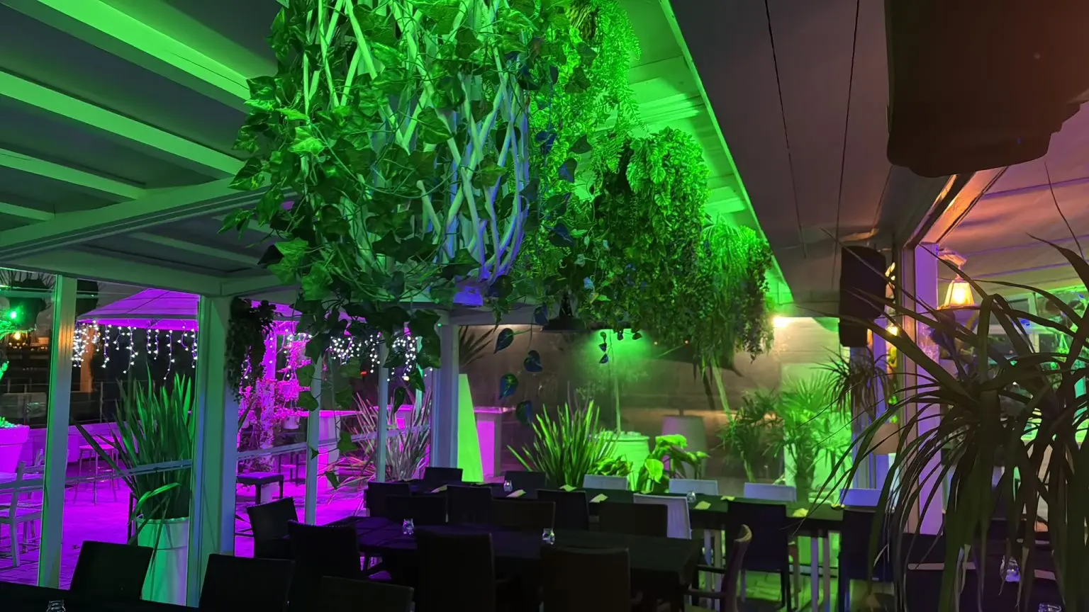 Veronello Lake Lounge di sera, con tavoli all'aperto e illuminazione scenografica